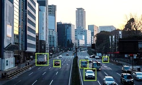 City traffic with each vehicle outlined by a detection box